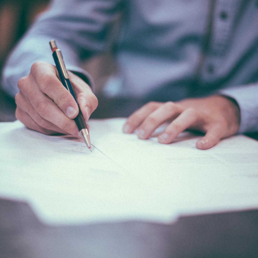 man writes with a pen